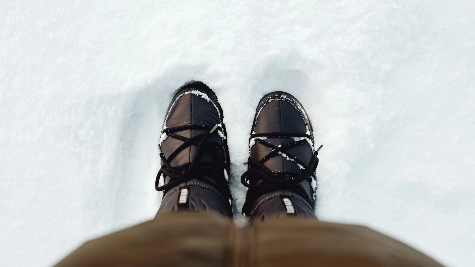 Close-up of winter boots in freshly fallen snow, perfect for cold season themes.