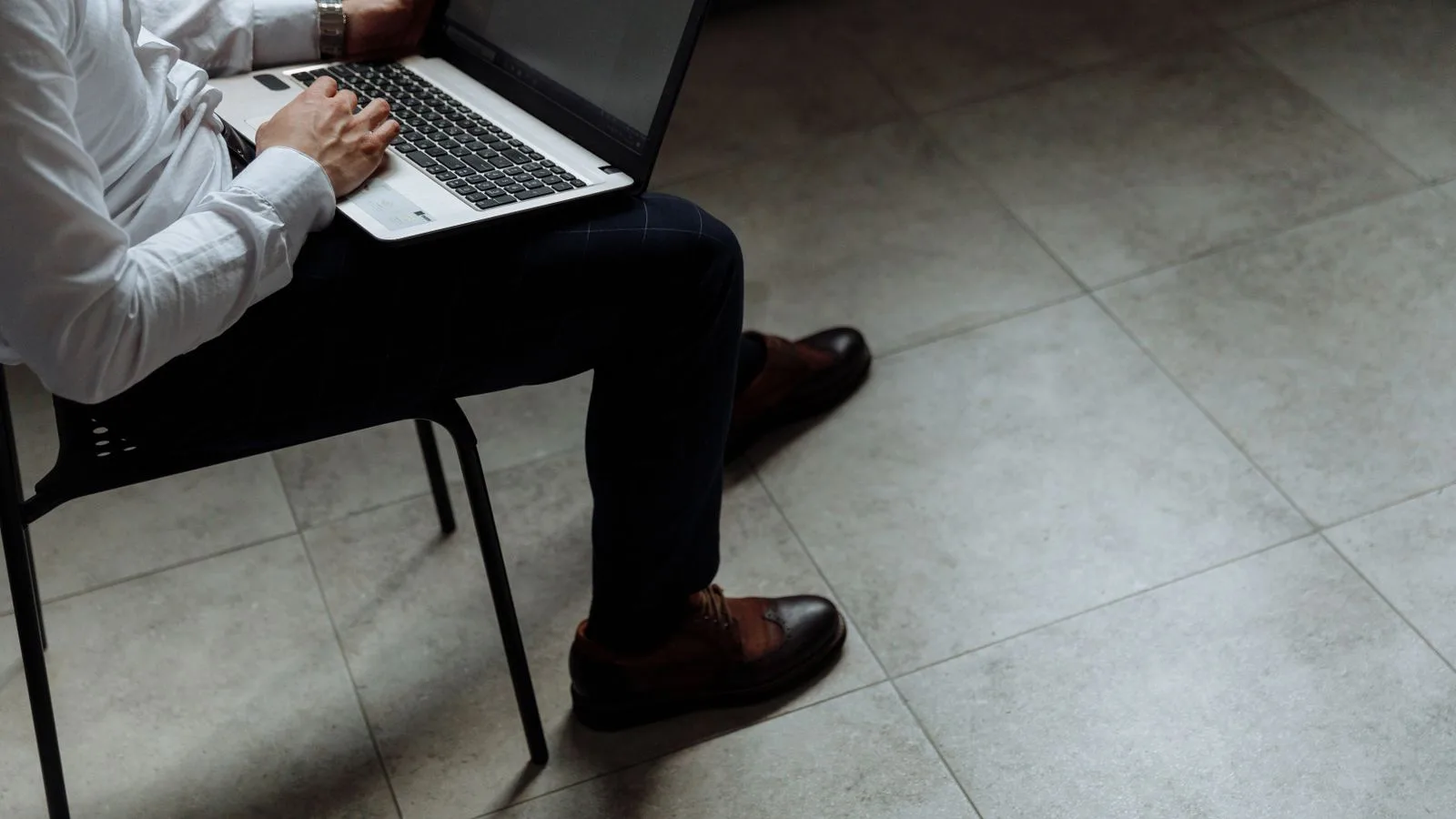Adult working on laptop indoors, emphasizing productivity and focus.