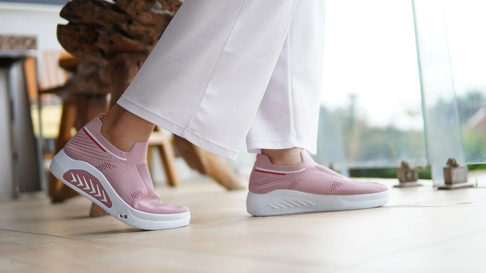 Fashionable pink sneakers paired with white pants, perfect for casual indoor settings.